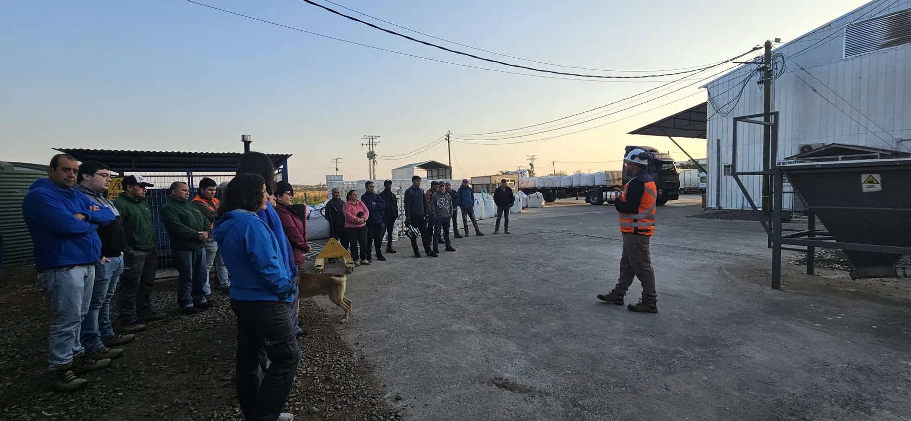 Charla de seguridad en terreno a un grupo de trabajadores en el exterior de una planta
