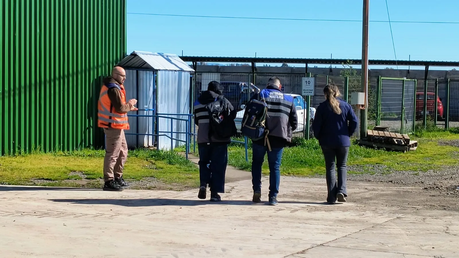 Asesor de Previc conversando con trabajadores en el patio de un centro de trabajo durante una fiscalización